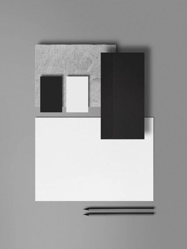monochromatyczna kompozycja przyborów papierniczych. białe, szare, czarne prostokąty na szarym tle